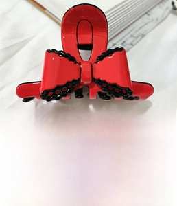 Detail of red acetate bow hair claw clip with black lace trim and 8cm size specification