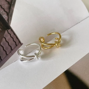 Minimalist knotted open rings in gold and silver finish on a clean white background