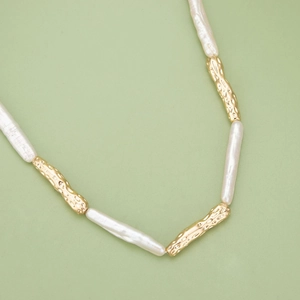 Collier en perles baroques et perles en métal texturé plaqué or 18k sur fond vert