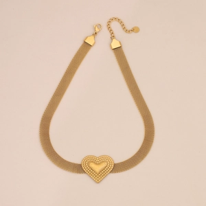 Detailed view of a gold heart pendant on a wide snake bone chain necklace with lobster clasp