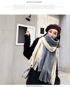Close-up of knit scarf with grey and cream color-blocking and fringe tassels details