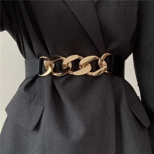 Detail of a chunky gold metal chain buckle on a black corset belt for blazers and coats