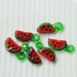 Macro shot of handmade glass watermelon slice pendants for DIY jewelry and crafts