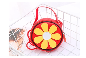 Dettaglio borsa a tracolla rotonda rossa per bambini in ecopelle con fiore giallo
