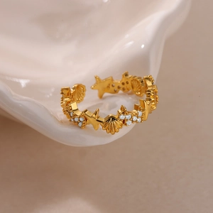 Detail of 18K gold starfish and seashell ring featuring white crystal accents on the band