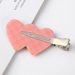 Close-up of pink checkered double-heart acetate hair clip with metal duckbill base