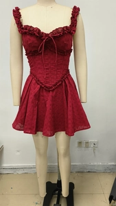 Detail of burgundy corset mini dress with intricate eyelet embroidery and lace trim