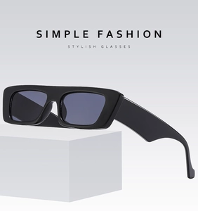 Fashionable black square sunglasses with wide legs on a geometric display stand