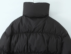 Detail of black puffer jacket showing high-loft padding and stand collar texture