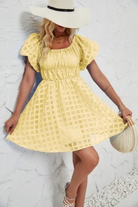 Gros plan d'une robe à carreaux jaune clair avec manches bouffantes et maille ajourée