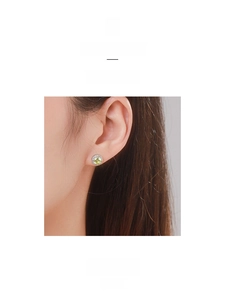 Close-up of S925 silver stud earring featuring a yellow-green gemstone and halo diamonds