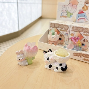 Cute animal crystal figurines with pink rabbit and black-white cat on wood surface