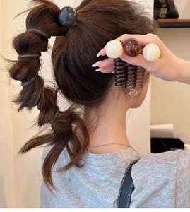 Detail of spiral hair ties with large round beads in various colors for high ponytail styling