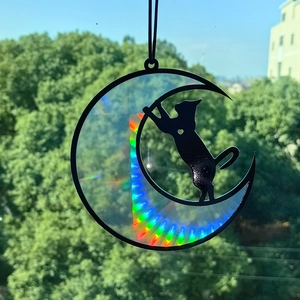 Detail of hanging black cat moon prism with vibrant rainbow holographic light effects