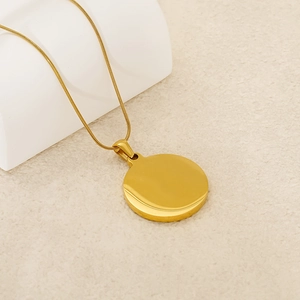 Minimalist gold coin pendant necklace with polished zodiac round disk on beige background