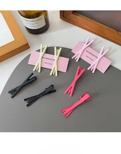 Close-up of X-shaped matte candy color hair clips in beige pink and magenta