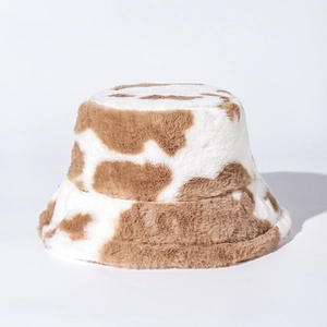 Close-up of the plush faux rabbit fur texture on a brown and white cow print bucket hat