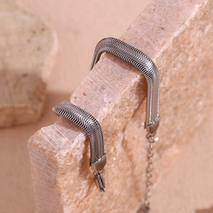 Vue macro de la texture d'un bracelet chaîne serpent 6mm argent sur pierre naturelle