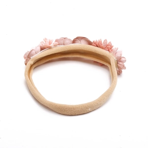 Detail of soft nylon infant headband with five 3D fabric flowers in pink gradients