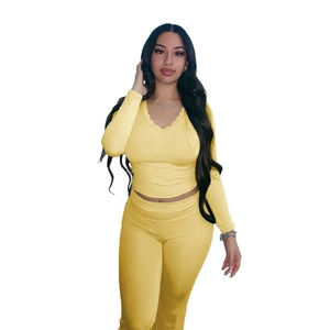 Detail of yellow two-piece set featuring V-neck long sleeve crop top and lace stitching