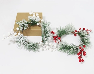Detailed view of snowy pine needle candle rings with realistic red and white berries