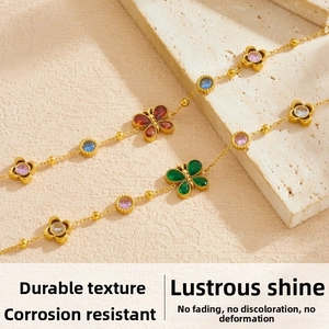 Dettaglio dei ciondoli a farfalla e fiore placcati in oro con zirconi colorati brillanti