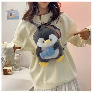 Close-up of a cute plush penguin backpack with small blue fish on a model's back