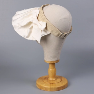 Detail of beige jacquard satin bow and metallic buckle on wide brim sun hat