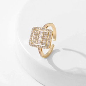 Detail of a square gold ring featuring pink pavé edges and baguette-cut zircon stones