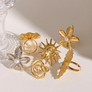 Set of gold and silver stainless steel flower rings with pearls and sunburst motifs