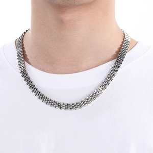 Macro shot of silver 10mm Jubilee style watch band chain necklace on a white t-shirt