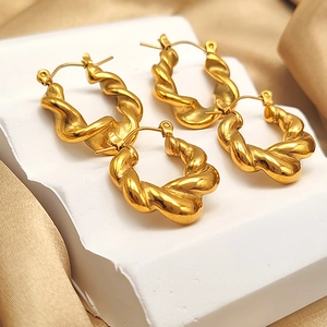 Detail of twisted rope gold earrings in two sizes on an elegant display base