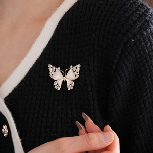 Detail of 18k gold plated butterfly brooch with white mother of pearl and zircon stones