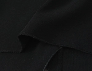 Vue macro détaillée de la couture overlock professionnelle sur un haut en tricot noir