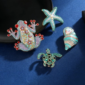 Detail of crystal sea animal brooches featuring frog, starfish, shell and turtle designs