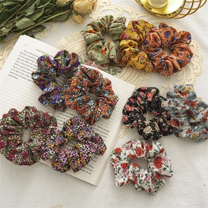 Flat lay of floral fabric scrunchies in various colors on vintage cottagecore background