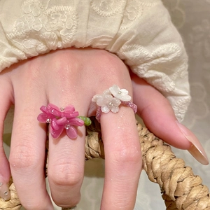 Detailed close-up of pink and white beaded flower rings with elastic resin band