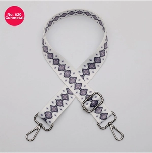 Detail of adjustable bag strap with purple geometric patterns and gunmetal hardware