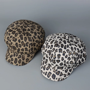 Macro detail of leopard print patterns on octagonal newsboy hats in brown and cream