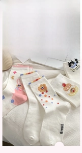 Détail de chaussettes en coton blanc avec broderies d'animaux et bords côtelés ondulés