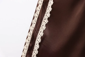 Detailed close-up of brown satin fabric with delicate white crochet lace trim detailing