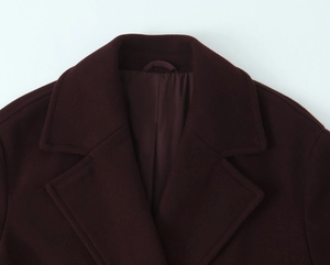 Detail of wool blend lapel and thick texture on a loose burgundy coat for women