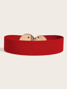 Detail of red elastic waist belt featuring a gold heart-shaped buckle and fine stitching