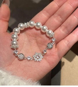 Detail of floral zircon pendant and white pearls on an elegant bracelet for women