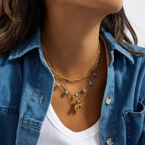 Collana a strati in acciaio al titanio dorato con pendente a lettera e perline di turchese