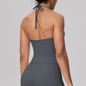 Detail of dark grey halter backless sports bra and high-waist leggings on a fitness model