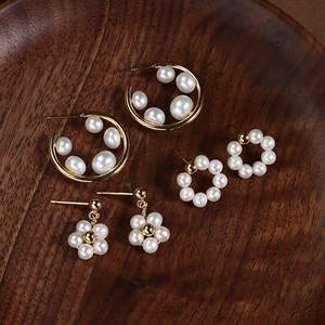 Three pairs of elegant gold-plated pearl earrings with S925 silver needles on wood