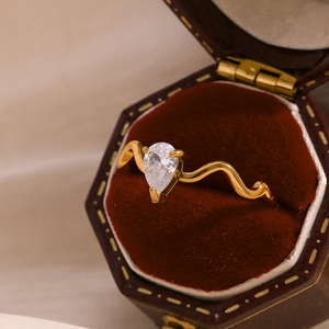Macro view of 18K gold snake ring with a pear-cut zircon in a vintage velvet box