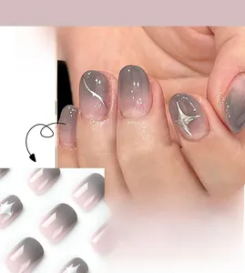 Detail of short square press-on nails with grey-pink gradient and silver star accents