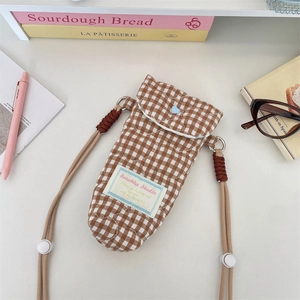 Close-up of quilted check camera bag with heart button and Sorakka Studio label